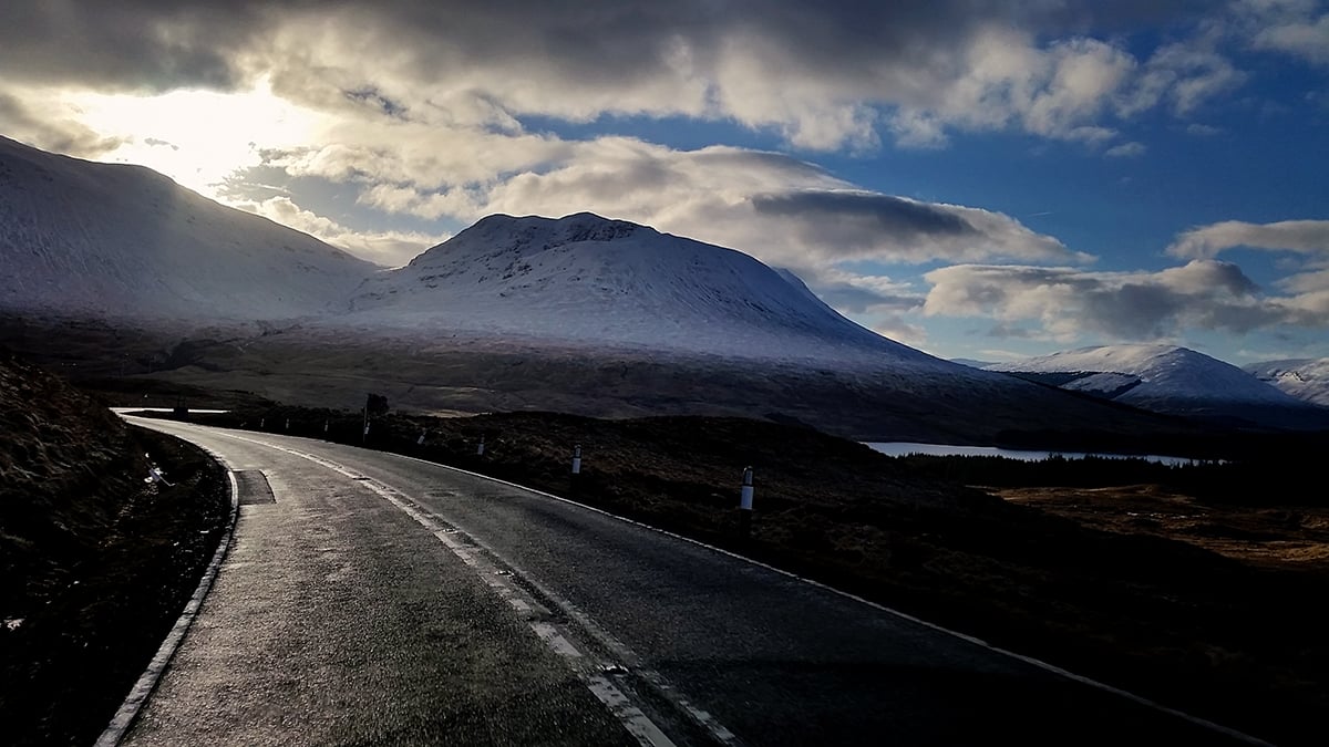 Scottish winding road leading to mountains