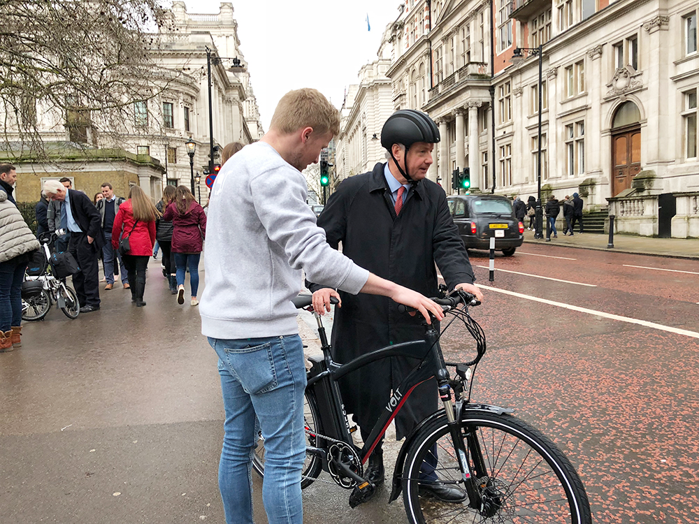 A VOLT Bikes representative shows a member of Parliament an electric bike